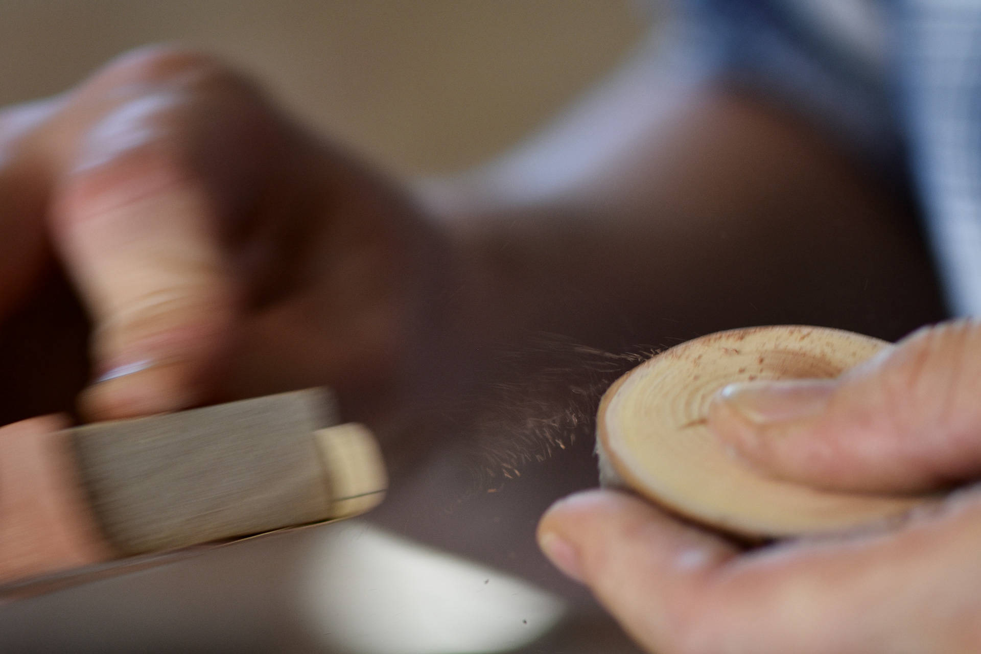 Kanten von Holzknöpfen und Kühlschrankmagneten werden von Hand gebrochen.